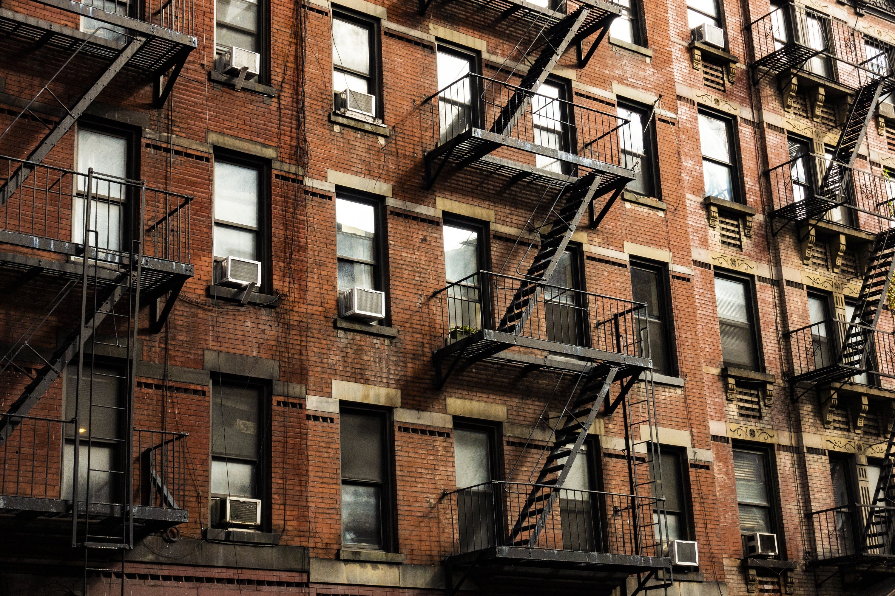 Brick building with fire escapes and air conditioning units